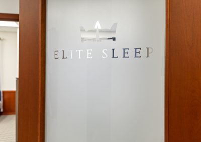 Photo of Elite Sleep's logo etched in glass on a door